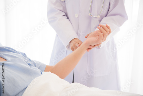 Doctor in professional working uniform taking care his patient and diagnosis symptoms on the bed.
