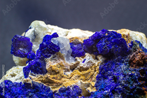 Macro blue azurite cluster on white matrix isolated crystal on black background 
