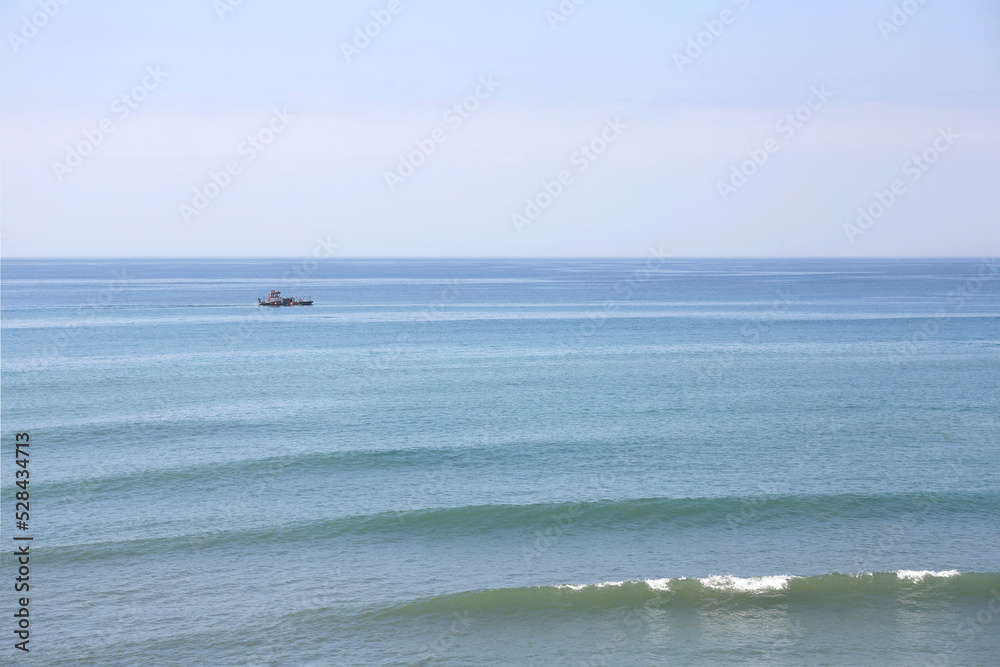Beautiful seascape. View of the sea surface of the water with waves and  the boat in a blurred focus. Alboran sea, Mediterranean sea.