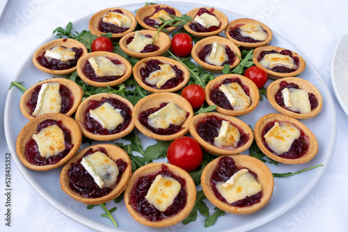 Mini red onion tartlets with goat's cheese on top. Closeup.