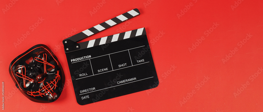 BLACK Clapper board and hacker mask on red background