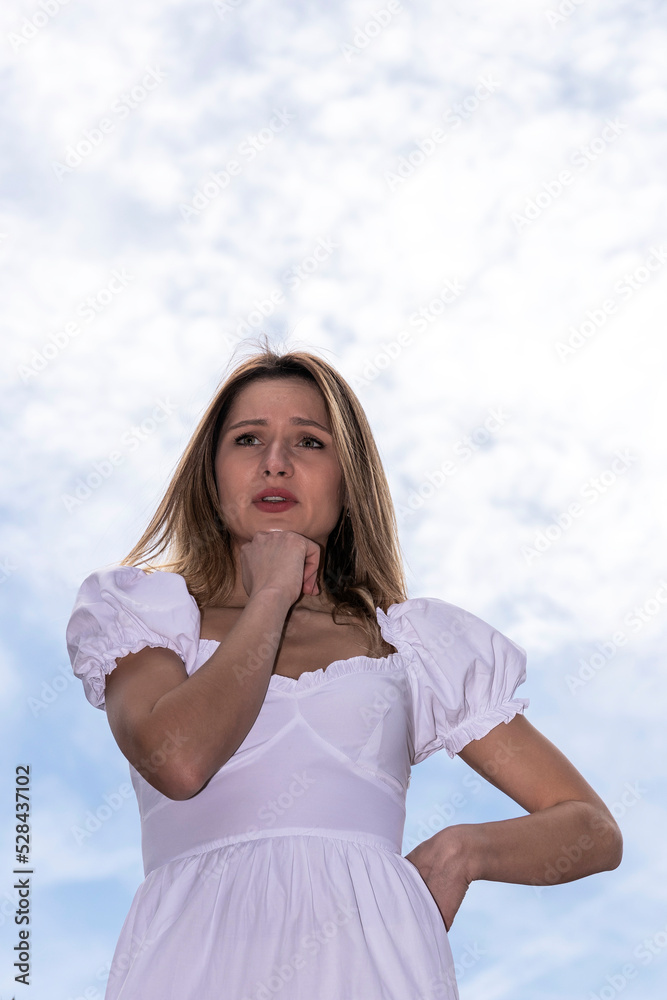 pensive blonde woman in white dress