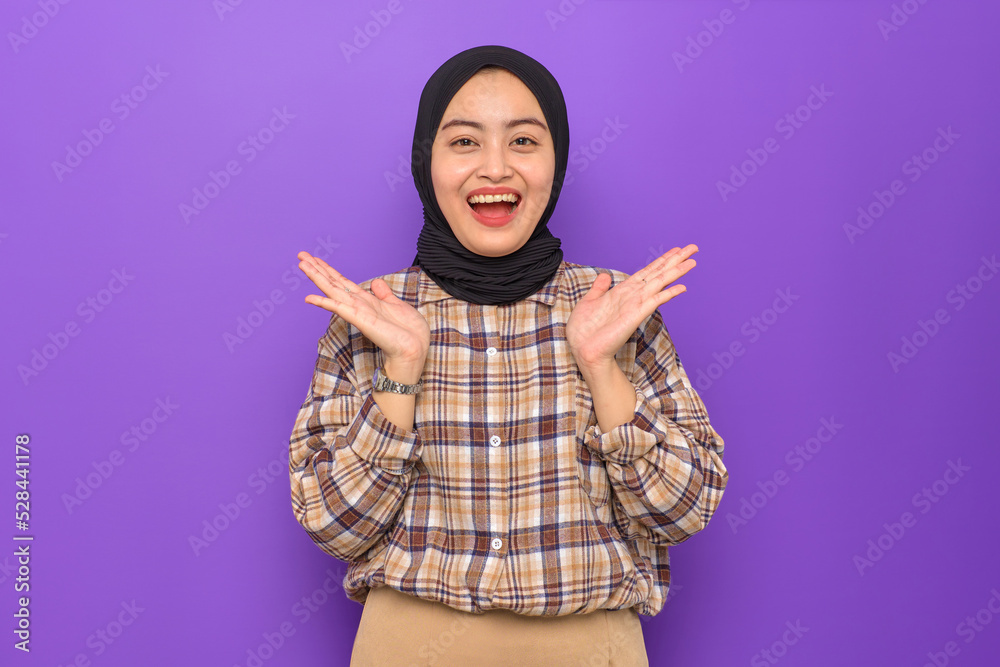 Amazed young Asian woman in plaid shirt looking at camera with wow face expression isolated on purple background Amazed young Asian woman in plaid shirt looking at camera with wow face expression isolated on purple background