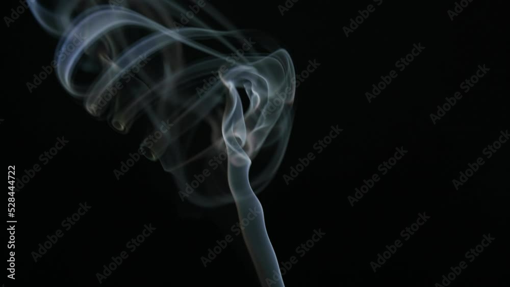 White smoke from incense stick flowing on black background White smoke from incense stick flowing on black background