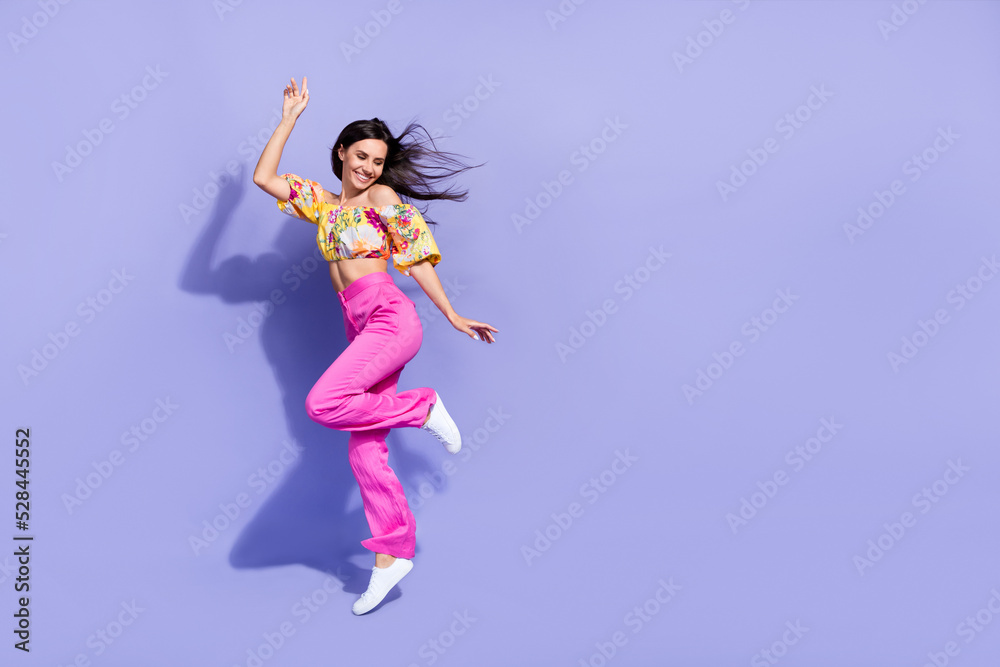 Full size portrait of excited carefree girl jump rejoice enjoy free time isolated on purple color background