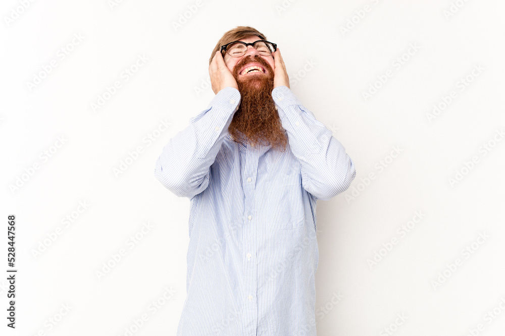 Young caucasian red-haired man isolated on white background laughs joyfully keeping hands on head. Happiness concept. Young caucasian red-haired man isolated on white background laughs joyfully keeping hands on head. Happiness concept.