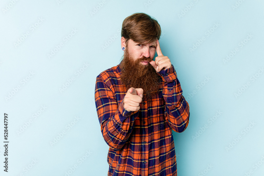 Young caucasian red-haired man isolated on blue background pointing temple with finger, thinking, focused on a task. Young caucasian red-haired man isolated on blue background pointing temple with finger, thinking, focused on a task.