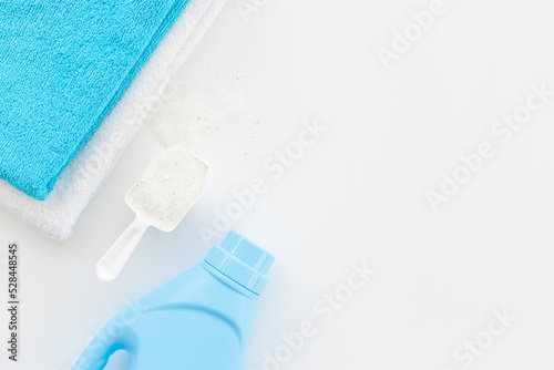 White washing powder with towels and a laundry conditioner bottle