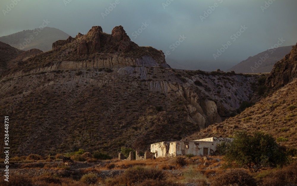 Landscape of abandoned house in oasis of desert against mountain. Almeria, Spain Landscape of abandoned house in oasis of desert against mountain. Almeria, Spain
