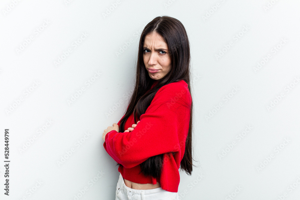 Young caucasian woman isolated on white background frowning face in displeasure, keeps arms folded. Young caucasian woman isolated on white background frowning face in displeasure, keeps arms folded.