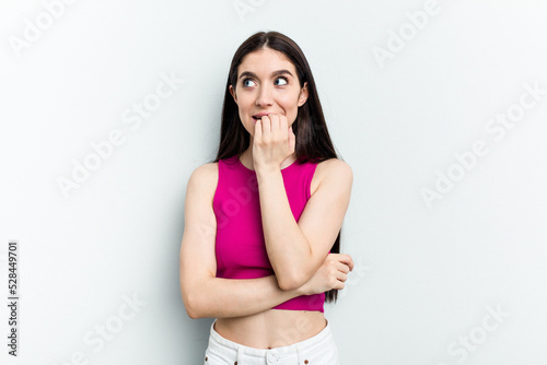 Young caucasian woman isolated on white background biting fingernails, nervous and very anxious.