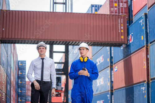Businessman and Technician team working planning the transportation for import or export at overseas shipping container yard.