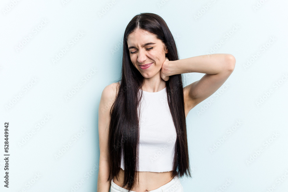 Young caucasian woman isolated on blue background suffering neck pain due to sedentary lifestyle. Young caucasian woman isolated on blue background suffering neck pain due to sedentary lifestyle.