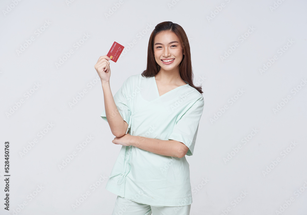 Happy asian woman patient showing credit card isolated on white background. Insurance allowance and charge indemnification concept. Happy asian woman patient showing credit card isolated on white background. Insurance allowance and charge indemnification concept.