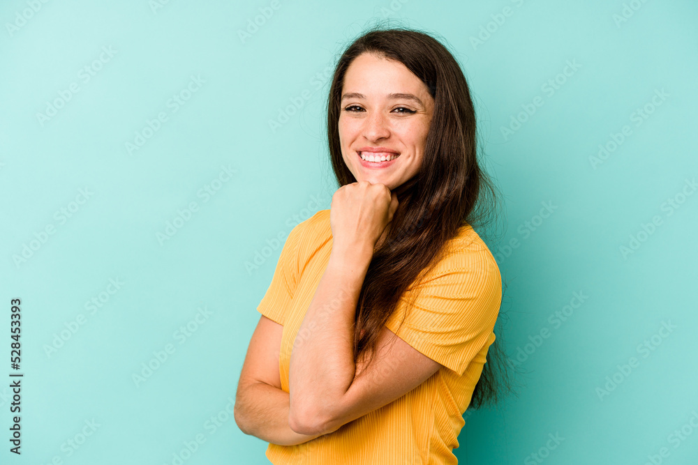 Young caucasian woman isolated on blue background smiling happy and confident, touching chin with hand. Young caucasian woman isolated on blue background smiling happy and confident, touching chin with hand.
