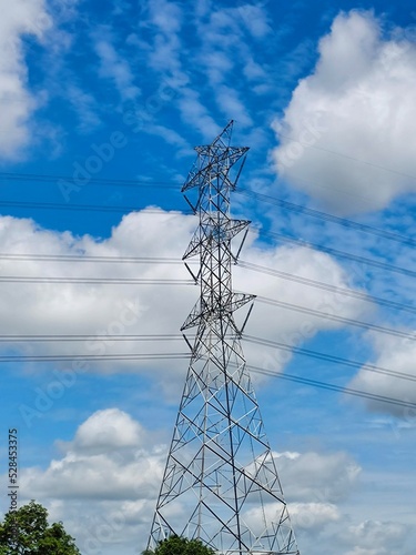 High voltage pole with blue sky ans white clouds.