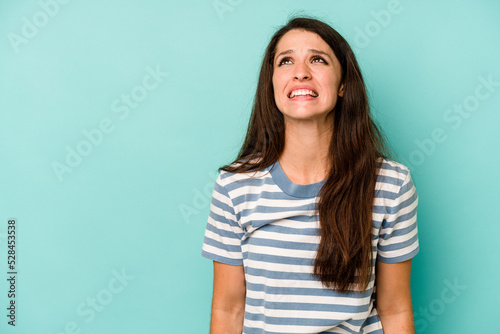 Young caucasian woman isolated on blue background shouting very angry, rage concept, frustrated. © Asier