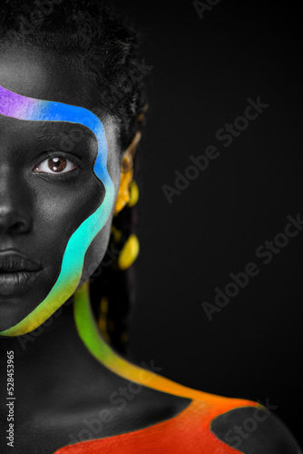 The Art Face. Rainbow body paint on african woman. Abstract creative lgbtq portrait. Bright fashion makeup on the girl. photo