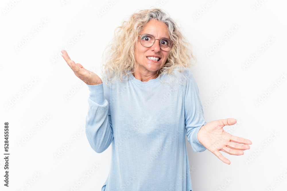 Middle age caucasian woman isolated on white background confused and doubtful shrugging shoulders to hold a copy space. Middle age caucasian woman isolated on white background confused and doubtful shrugging shoulders to hold a copy space.