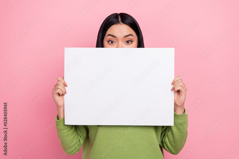 Photo of brunette millennial lady hold poster cover face wear green jumper isolated on pink color background Photo of brunette millennial lady hold poster cover face wear green jumper isolated on pink color background