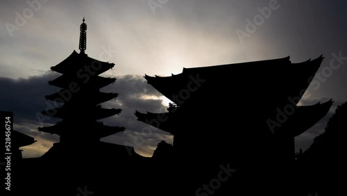Sensoji-ji Temple in Asakusa, Tokyo. Timelapse at Sunrise with Fast Clouds and Dark Silhouette of Gate and Pagoda, Japan