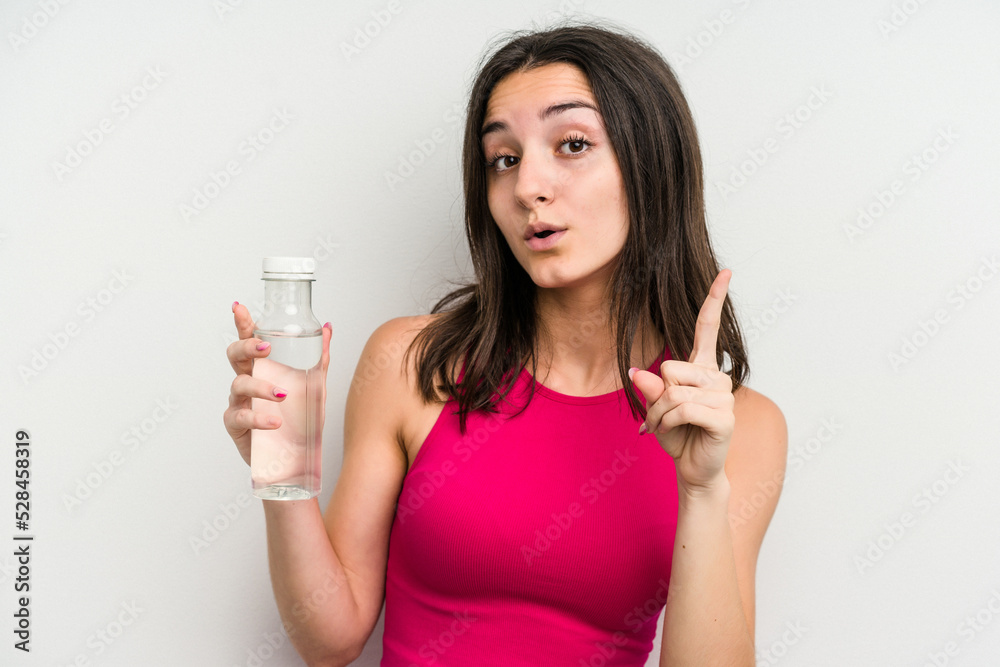 Young caucasian woman holding a bottle of water isolated on white background having an idea, inspiration concept. Young caucasian woman holding a bottle of water isolated on white background having an idea, inspiration concept.