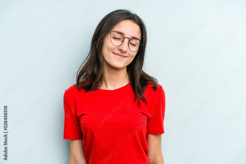Young caucasian woman isolated on blue background laughs and closes eyes, feels relaxed and happy. Young caucasian woman isolated on blue background laughs and closes eyes, feels relaxed and happy.