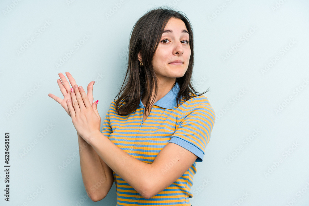 Obraz premium Young caucasian woman isolated on blue background feeling energetic and comfortable, rubbing hands confident.