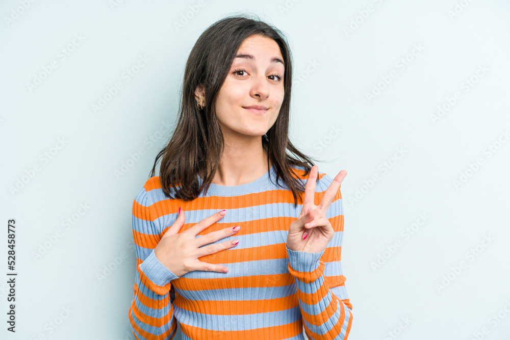 Young caucasian woman isolated on blue background taking an oath, putting hand on chest. Young caucasian woman isolated on blue background taking an oath, putting hand on chest.