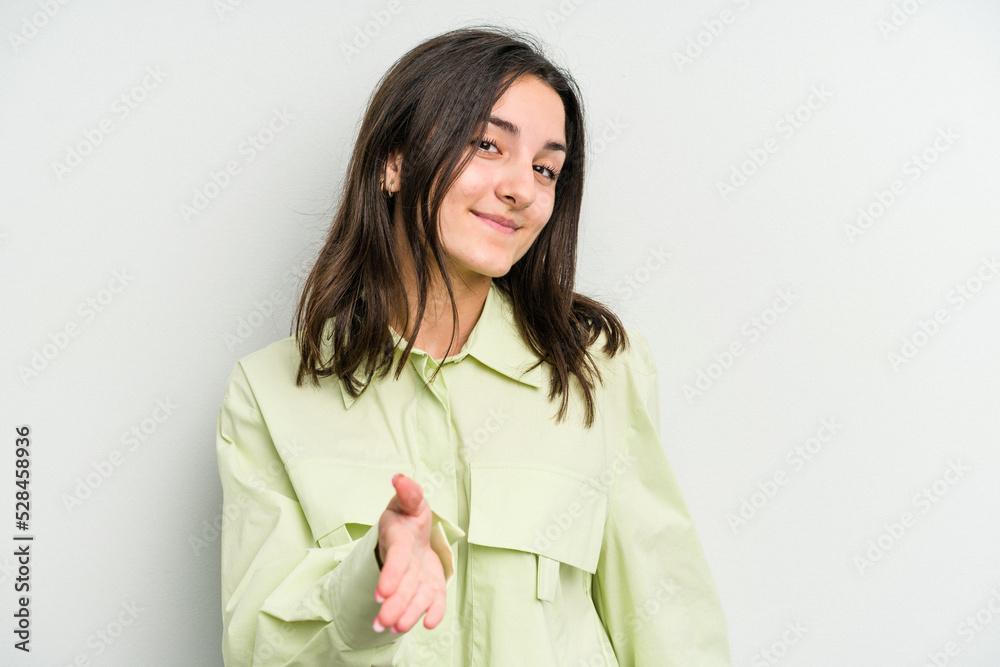 Young caucasian woman isolated on white background stretching hand at camera in greeting gesture. Young caucasian woman isolated on white background stretching hand at camera in greeting gesture.