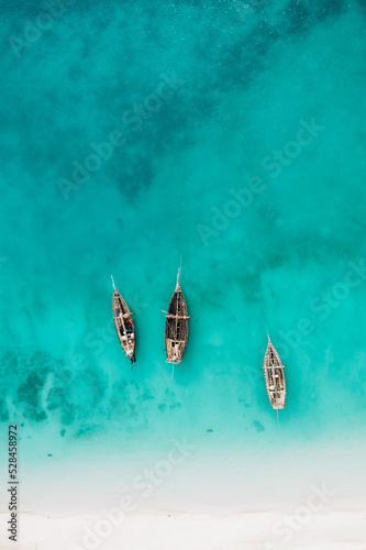 Top view or aerial view of Beautiful crystal clear water and white beach with long tail boats in summer of Zanzibar island © olyphotostories