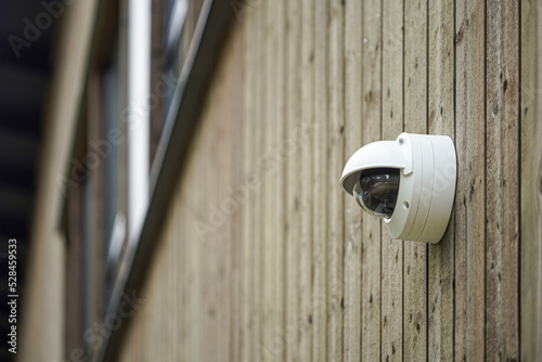 Round shaped weathersealed Security camera on the wooden wall
