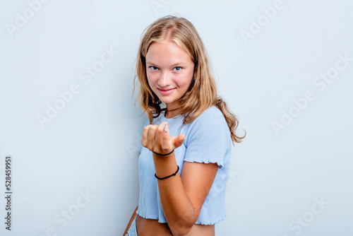 Принти на полотні Caucasian teen girl isolated on blue background pointing with finger at you as if inviting come closer