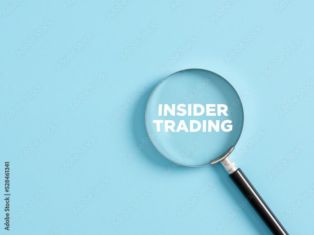 Magnifier with the text insider trading on blue background. Magnifier with the text insider trading on blue background.