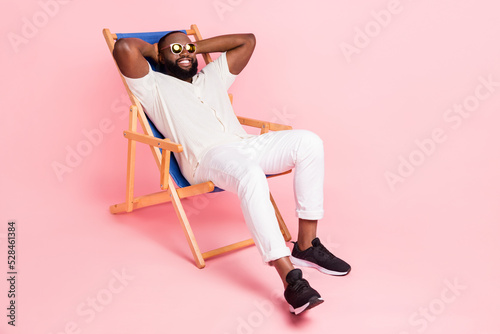 Photo of adorable funny guy dressed white shirt sitting deck chair arms behind h Fototapet