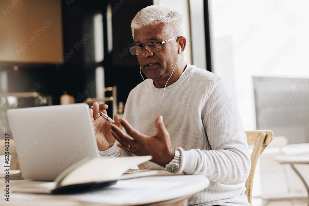Businessman having an online meeting while working from home Businessman having an online meeting while working from home