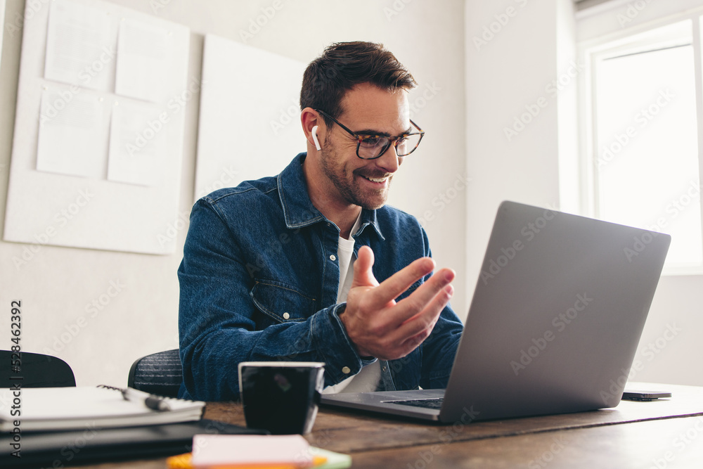 Happy businessman speaking with his team on a video call Happy businessman speaking with his team on a video call