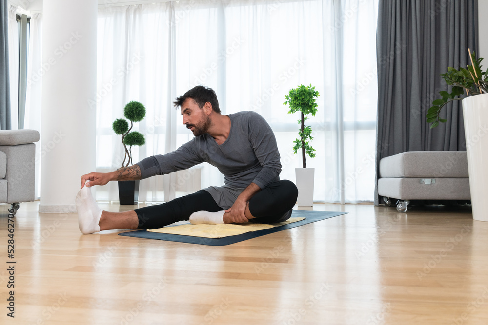 Young man rehabilitation exercise at home after car crash accident. Recovery workout of young guy with yoga training poses for stretching the muscles. Physical therapy exercising Young man rehabilitation exercise at home after car crash accident. Recovery workout of young guy with yoga training poses for stretching the muscles. Physical therapy exercising