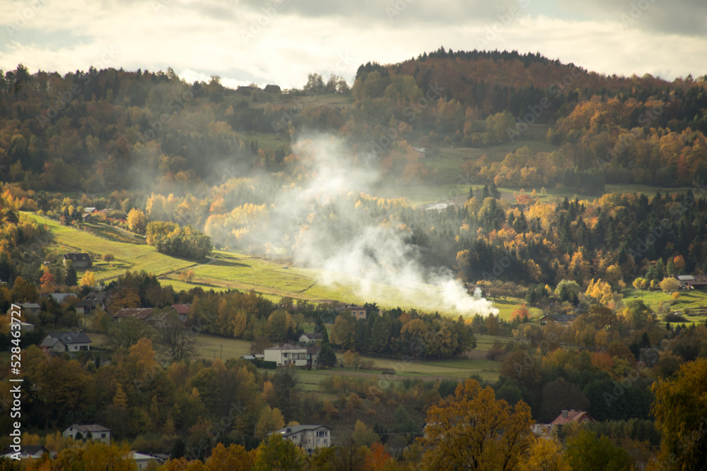 Fog and sunlight in rural scenery. Landscape taken with telephoto lens on autumn. 