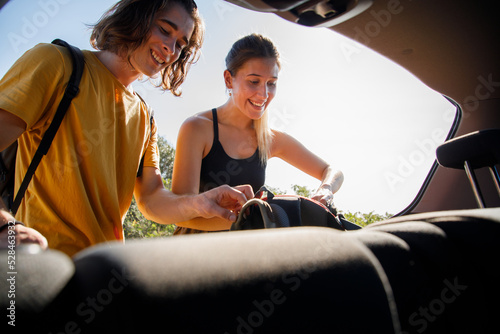 Foto Hiking Caucasian couple unloading summer hiking equipment from car