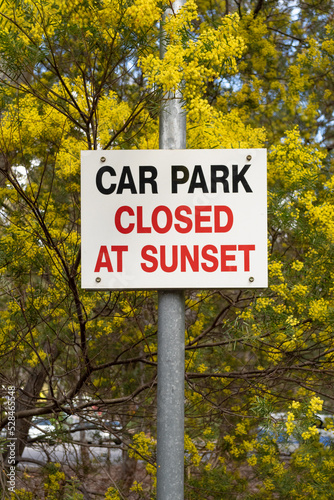 Car park closed at sunset road sign in the park with yellow wattle background