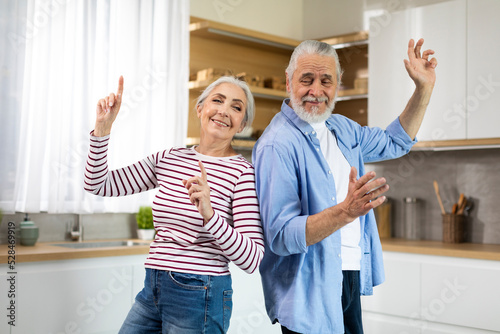 Home Fun. Joyful Senior Spouses Dancing Together In Kitchen Interior