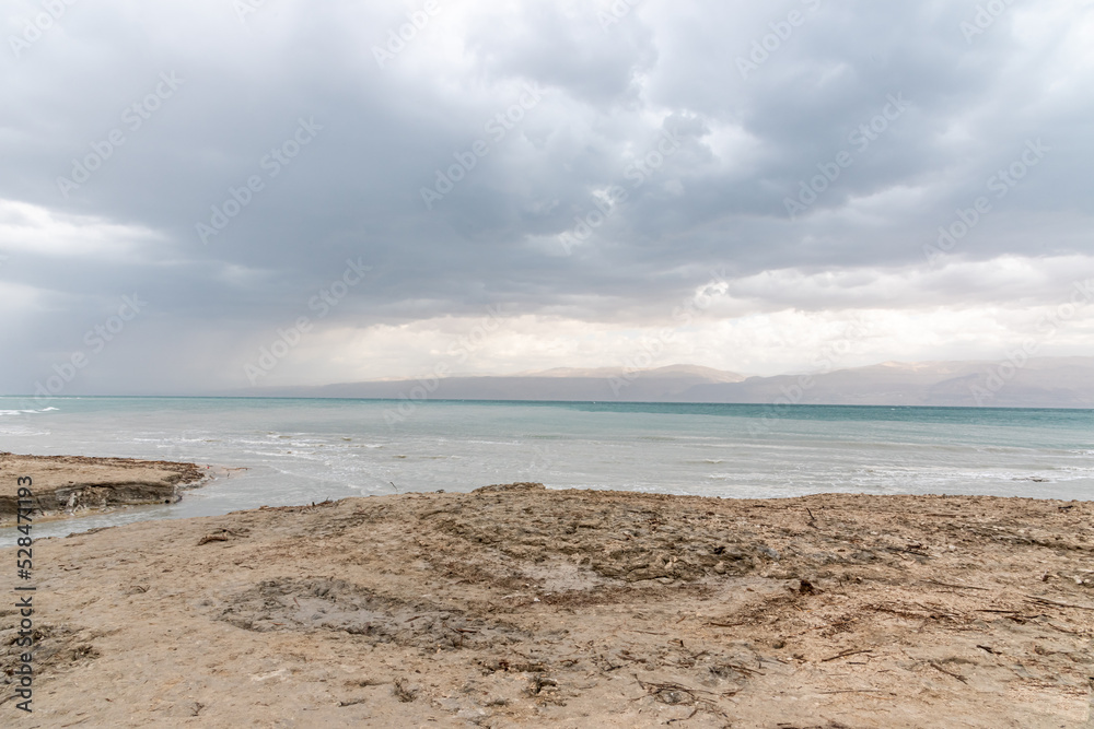 Exotic view of the sinkhole area of the Dead Sea on a stormy winter day. PhotoStorm and rain at the Dead Sea coastline. Salt crystals at sunset. The texture of the Dead sea. Salty seashore. High Exotic view of the sinkhole area of the Dead Sea on a stormy winter day. PhotoStorm and rain at the Dead Sea coastline. Salt crystals at sunset. The texture of the Dead sea. Salty seashore. High