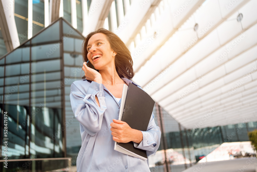 Attractive brunette businesswoman talking mobile phone with client. Pretty caucasian female business person smile when phone conversation Attractive brunette businesswoman talking mobile phone with client. Pretty caucasian female business person smile when phone conversation