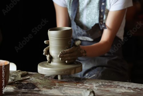 Pottery workshop. A potter teaches a woman to make a clay pot. Great hobby and education activity for people to relax.