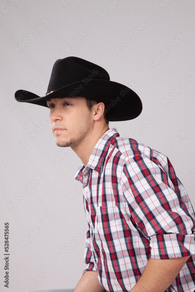 Thoughtful cowboy in plaid shirt and hat Thoughtful cowboy in plaid shirt and hat