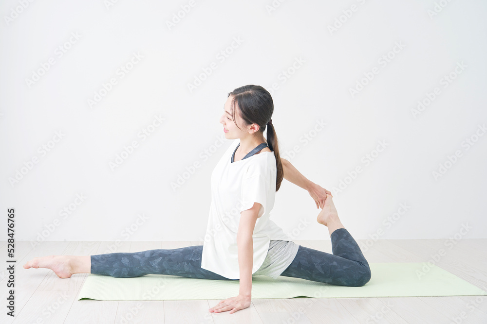 Fototapeta premium リビングで柔軟運動をする女性