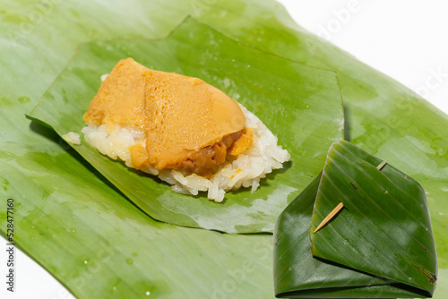 Sticky rice and egg custard wrapped in banana leaf Traditional thai desserts, on white background