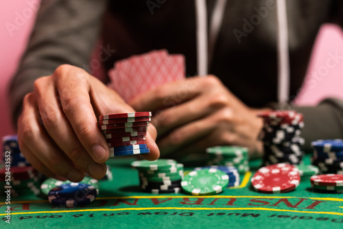 Casino, gambling and entertainment concept - stack of poker chips on a green table. photo