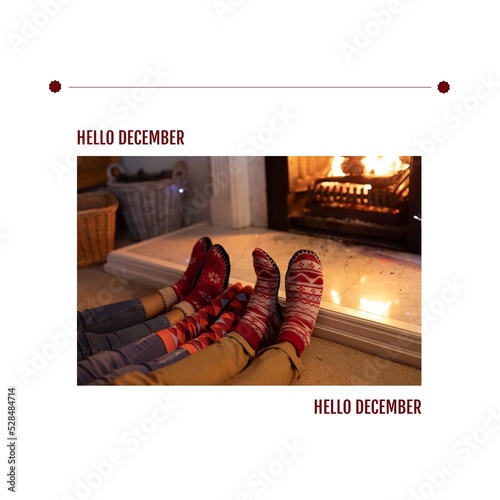 Hello december text over low section of parents with child wearing socks relaxing by fireplace